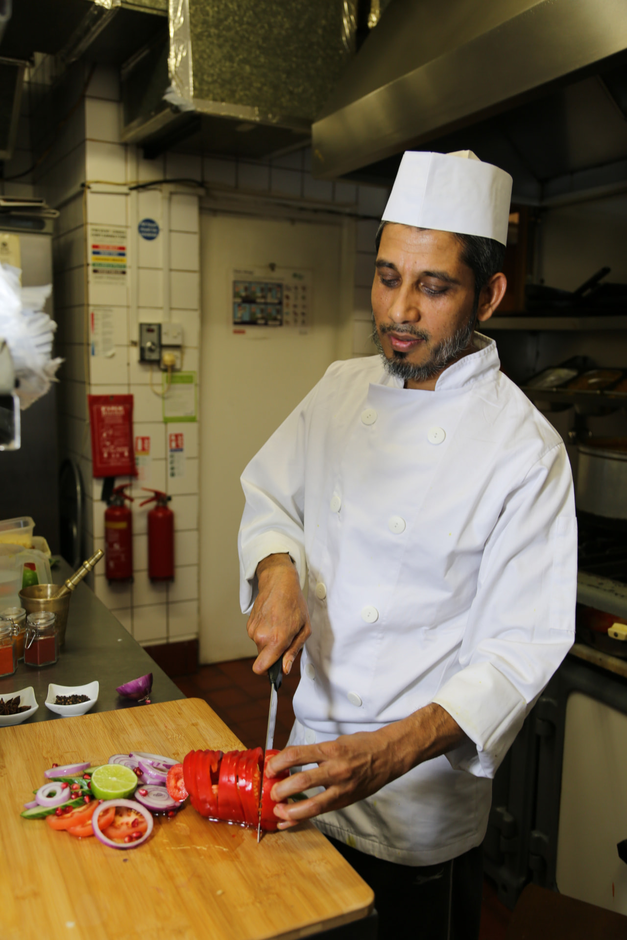 Photograph 1 of 6: Chef preparing fresh spices and vegetables on the kitchen pass at Jaflong Tandoori